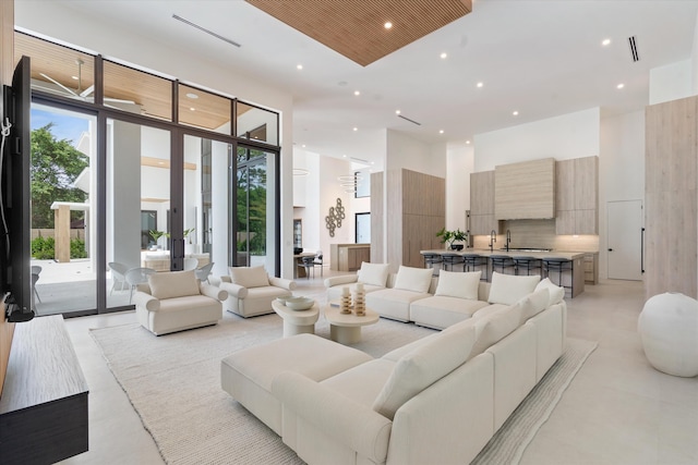 living room featuring expansive windows, french doors, plenty of natural light, and a high ceiling