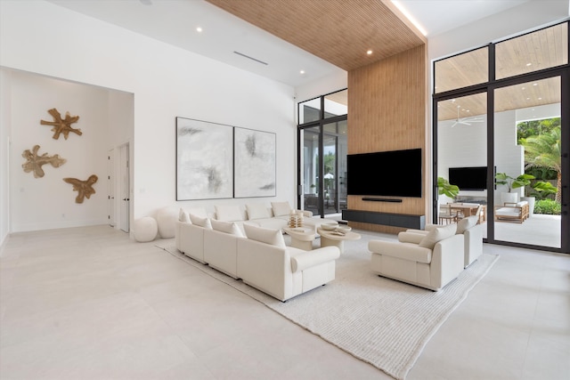 living room featuring a high ceiling and a wall of windows