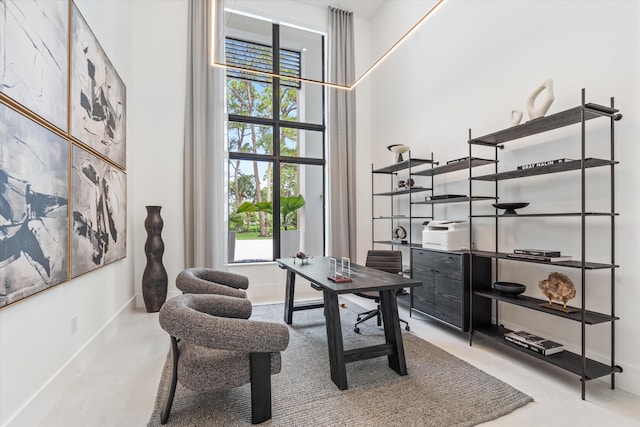 home office with carpet flooring and a towering ceiling