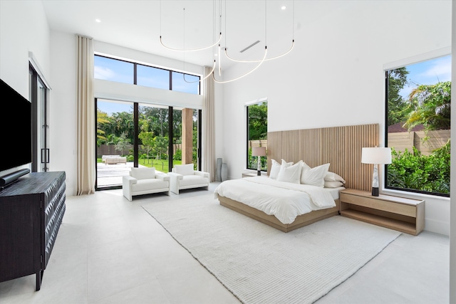 bedroom featuring an inviting chandelier and a towering ceiling