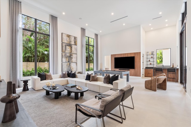 living room with light colored carpet and a towering ceiling