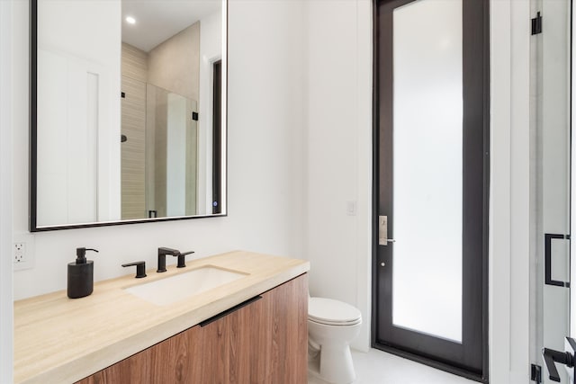 bathroom with vanity, toilet, and a shower