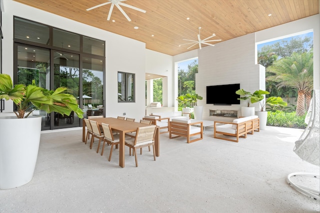 sunroom with ceiling fan with notable chandelier, wooden ceiling, and a fireplace