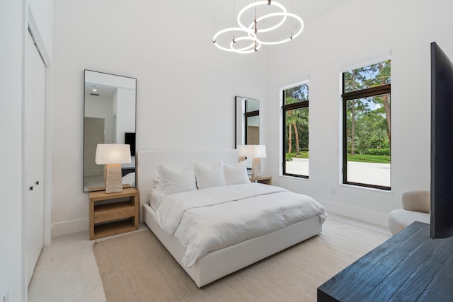 bedroom with a towering ceiling, a closet, and a notable chandelier