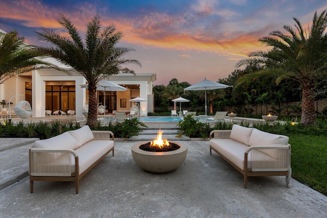 patio terrace at dusk featuring an outdoor living space with a fire pit