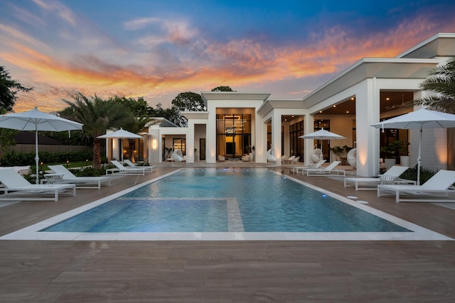 pool at dusk featuring a patio area