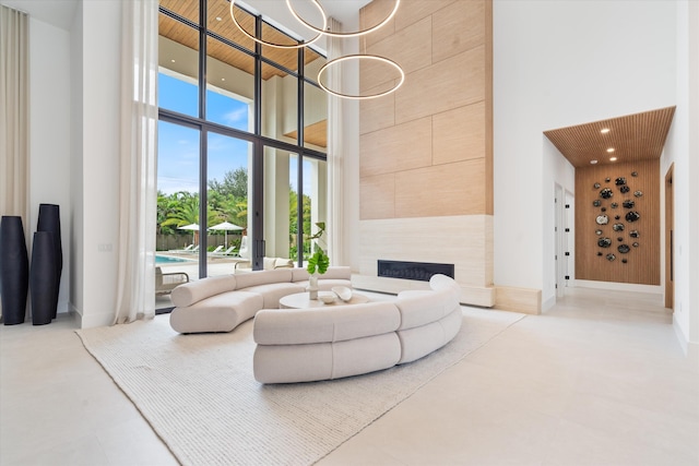 living room featuring a high ceiling, expansive windows, and a large fireplace