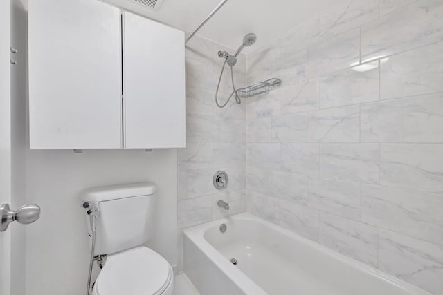 bathroom featuring tiled shower / bath and toilet