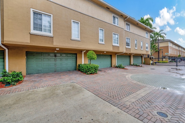 exterior space with fence, an attached garage, and driveway
