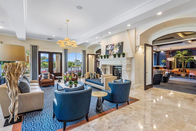 living room featuring french doors, an inviting chandelier, a high end fireplace, beamed ceiling, and ornamental molding