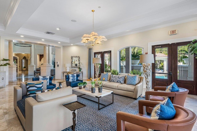 living room with decorative columns, french doors, ornamental molding, and an inviting chandelier