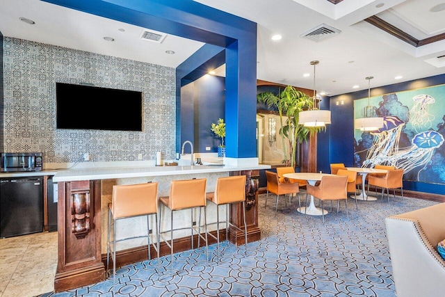 bar featuring pendant lighting, refrigerator, ornamental molding, and coffered ceiling