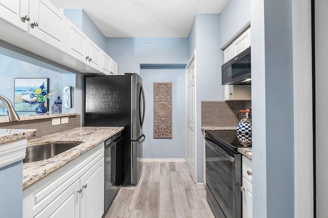 kitchen featuring black appliances, sink, white cabinets, and backsplash