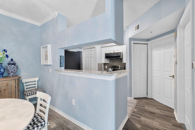 kitchen with white cabinetry, kitchen peninsula, fridge, stainless steel range with electric cooktop, and exhaust hood