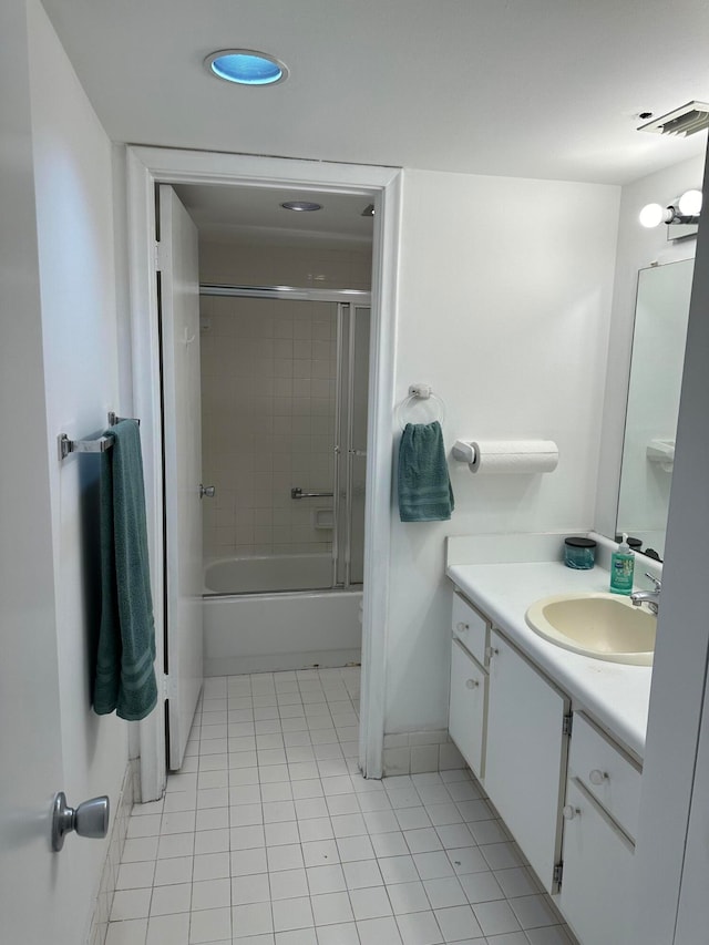 bathroom featuring tile patterned floors, vanity, and enclosed tub / shower combo