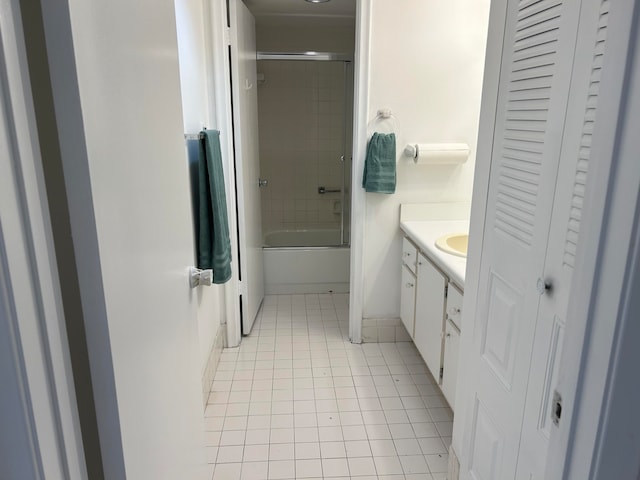 bathroom featuring bath / shower combo with glass door, tile patterned flooring, and vanity