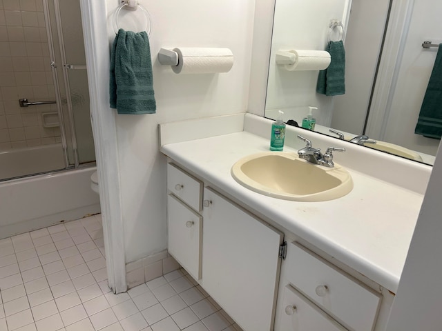 full bathroom featuring enclosed tub / shower combo, vanity, toilet, and tile patterned floors