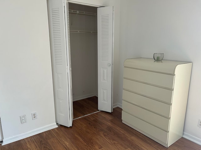 unfurnished bedroom with a closet and dark hardwood / wood-style floors