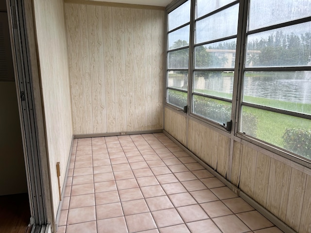 unfurnished sunroom with a water view and a healthy amount of sunlight