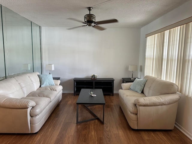 living room featuring ceiling fan, dark hardwood / wood-style floors, and a textured ceiling