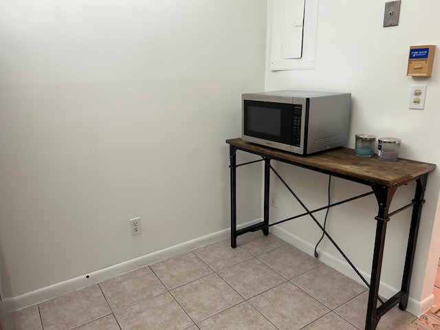 interior space with light tile patterned flooring and electric panel