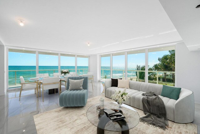 tiled spare room with a wall of windows, a water view, and a view of the beach