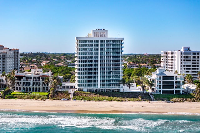 view of building exterior with a beach view and a water view