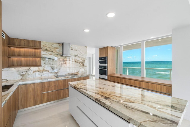 kitchen featuring brown cabinetry, backsplash, modern cabinets, and open shelves