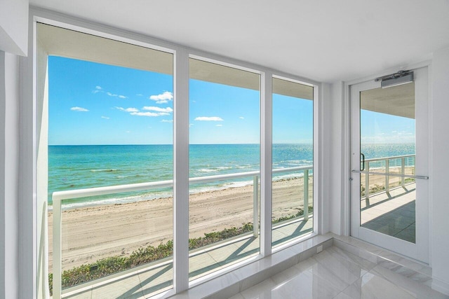 interior space with a water view and a view of the beach