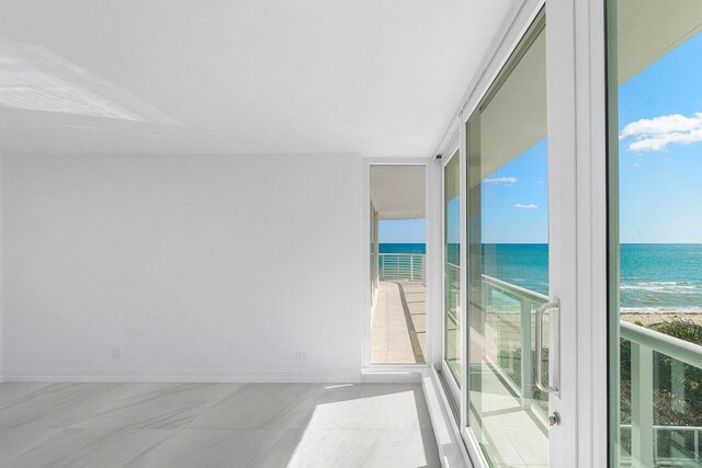 balcony featuring a water view and a beach view