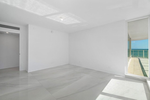 empty room featuring baseboards and marble finish floor