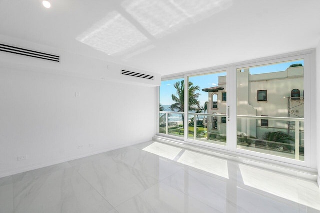 empty room with a wall of windows, visible vents, baseboards, and marble finish floor