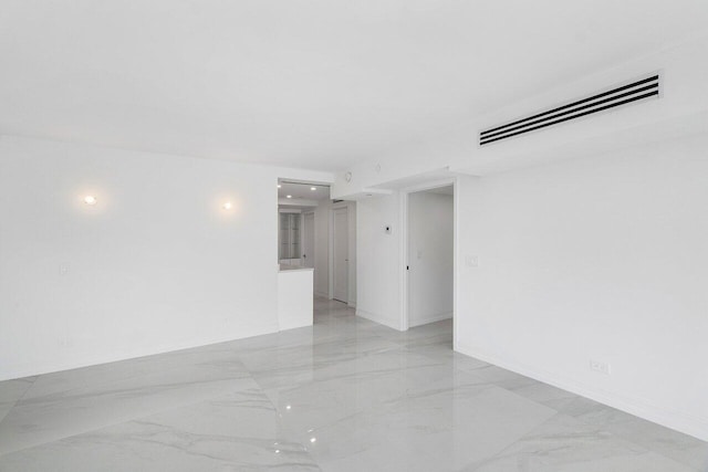 spare room featuring visible vents, marble finish floor, and baseboards