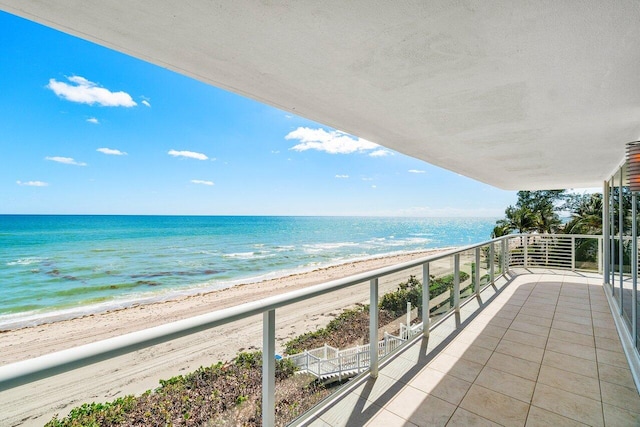 balcony featuring a view of the beach and a water view