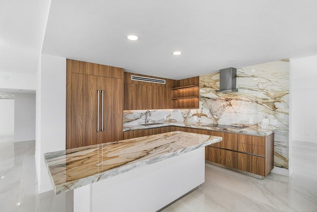 kitchen featuring a sink, brown cabinets, extractor fan, and modern cabinets