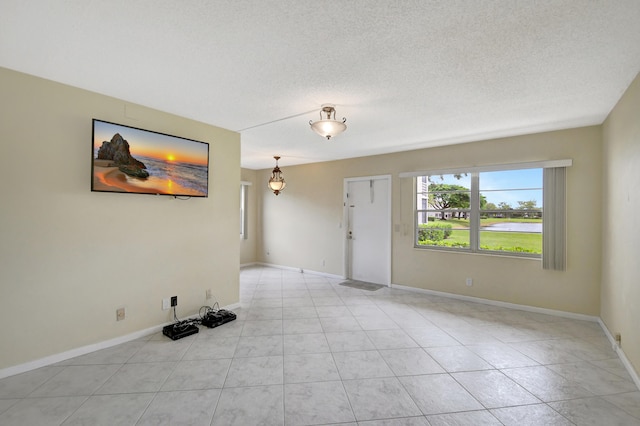 tiled empty room with a textured ceiling