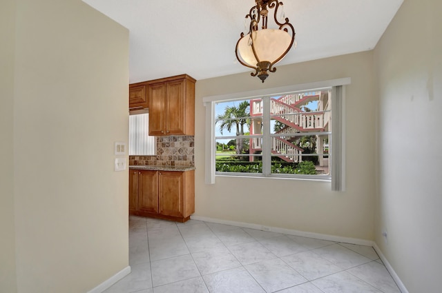 unfurnished dining area with light tile patterned flooring