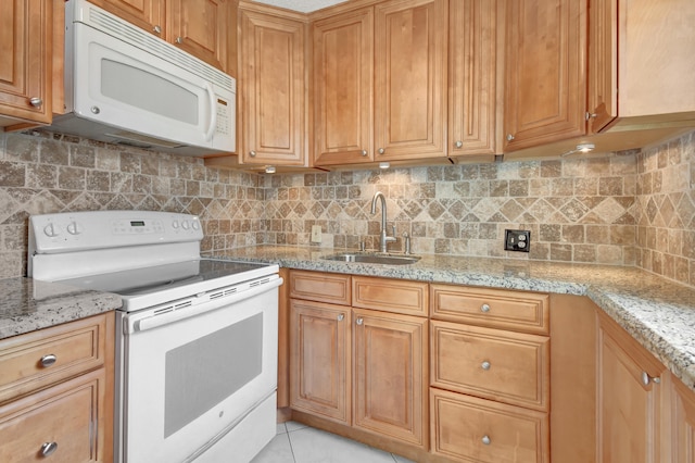 kitchen with decorative backsplash, sink, light tile patterned floors, light stone counters, and white appliances