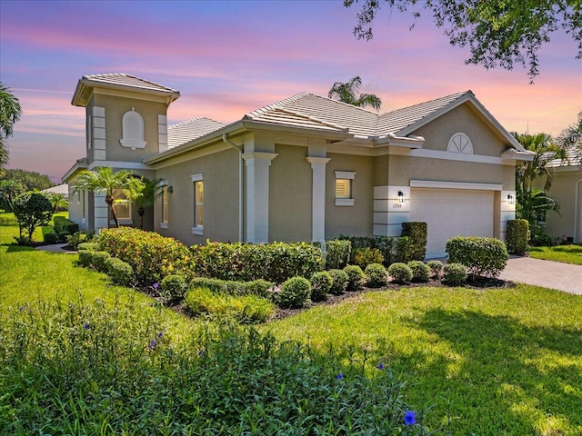 view of front of property featuring a yard and a garage