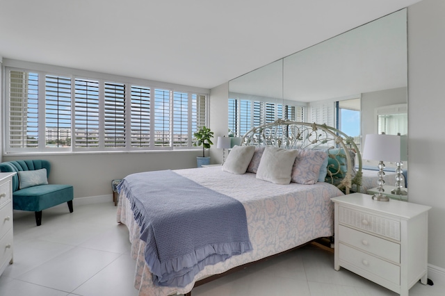 bedroom with light tile patterned floors and multiple windows