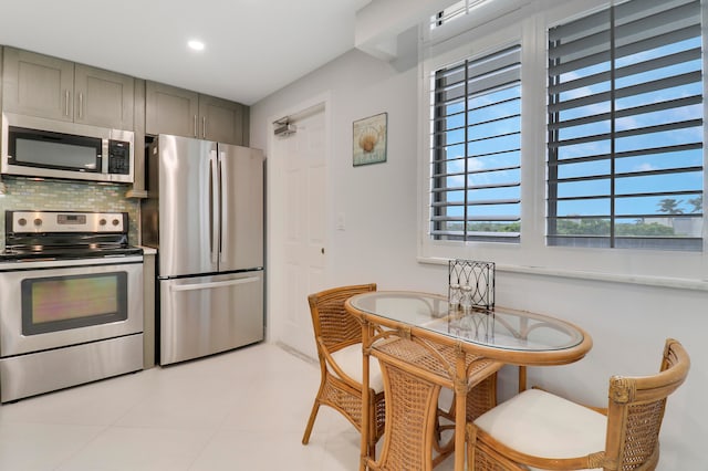 kitchen featuring gray cabinets, stainless steel appliances, tasteful backsplash, and a wealth of natural light