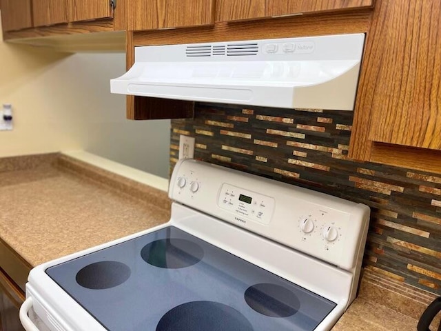 interior details with ventilation hood, decorative backsplash, and white range