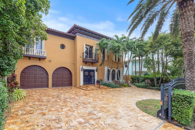 mediterranean / spanish home featuring a balcony and a garage