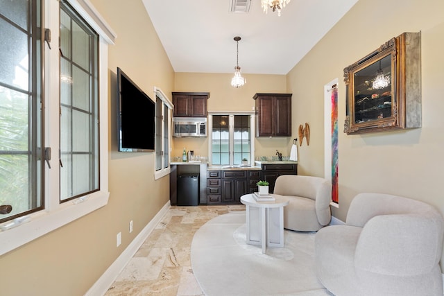 interior space with dark brown cabinetry and hanging light fixtures