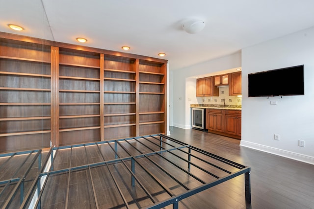 unfurnished living room with dark hardwood / wood-style floors, beverage cooler, and sink