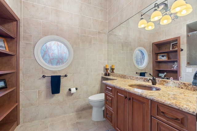 bathroom featuring vanity, toilet, and tile walls