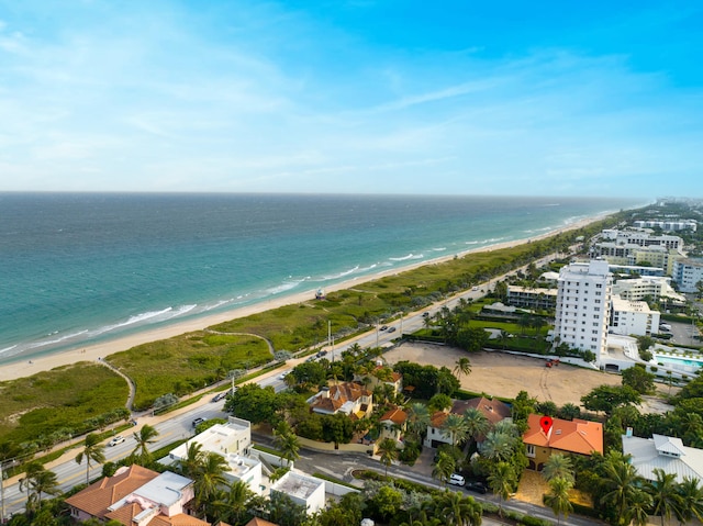 birds eye view of property with a water view and a beach view