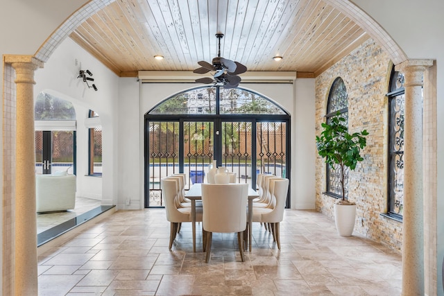 dining space with wooden ceiling, a high ceiling, french doors, ceiling fan, and ornate columns