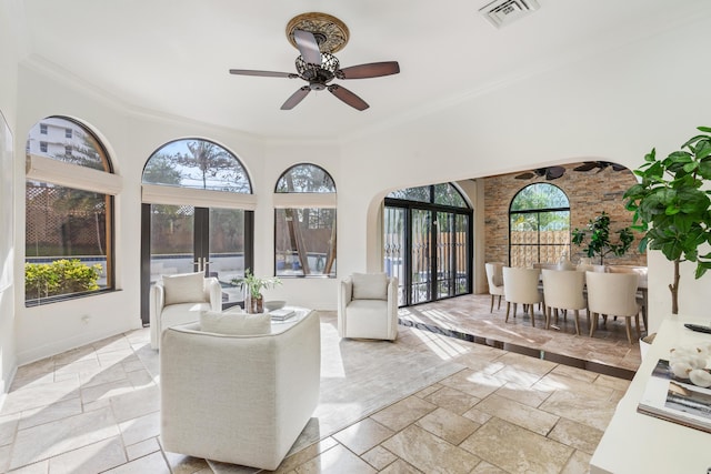 interior space with french doors, ornamental molding, ceiling fan, and a healthy amount of sunlight