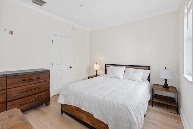 bedroom featuring light hardwood / wood-style floors and crown molding